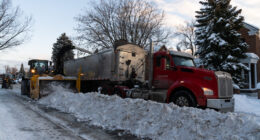Un tracteur remplit un camion de chargement de neige